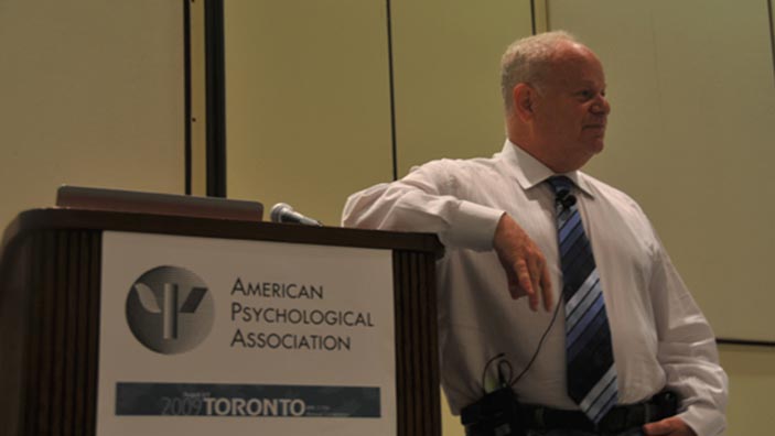 Martin Seligman leans on podium