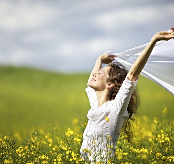 Young-happy-woman-standing-in-field.jpg