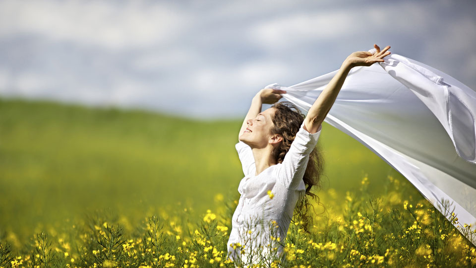 Young-happy-woman-standing-in-field.jpg