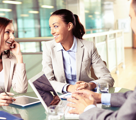 Two women smiling during a work meeting.