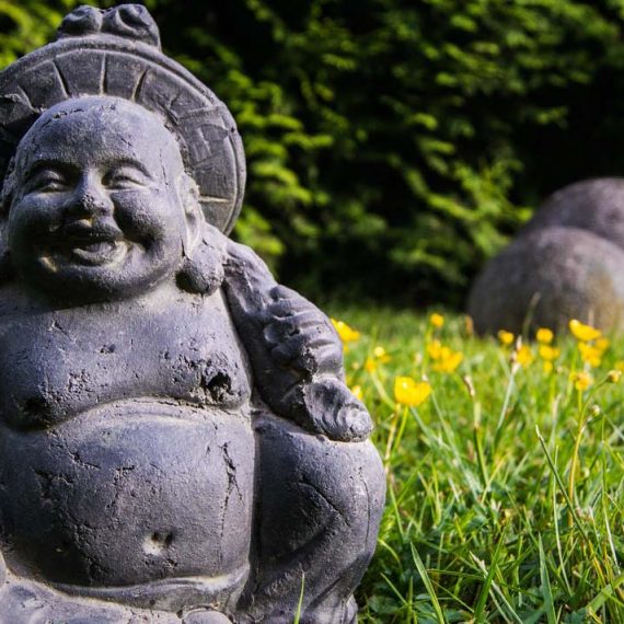 Smiling Buddha in Grass with Yellow Flowers