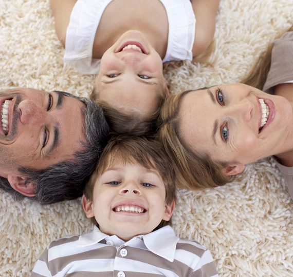 Family lying on floor with their heads touching