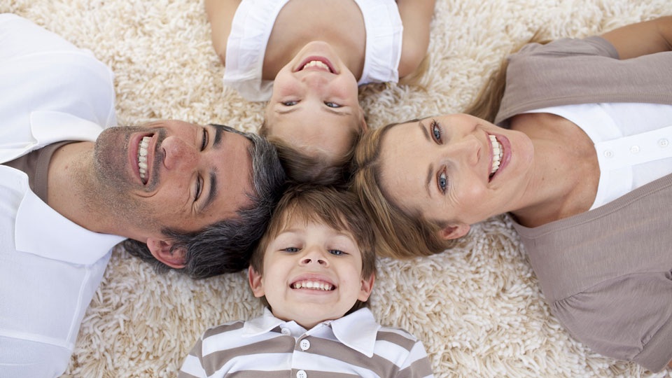 Family lying on floor with their heads touching