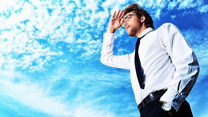 Businessman standing looking upward