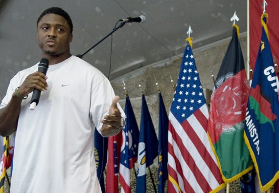 Warrick Dunn talking in front of flags