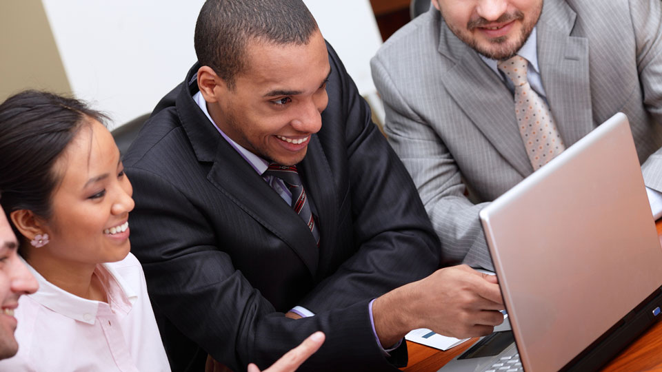 Business team looks at a computer