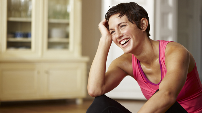 Happy woman in pink workout top.