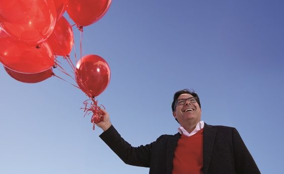 Shane Lopez holding a bunch of red balloons