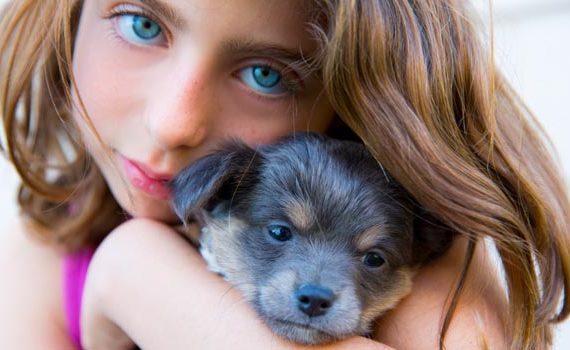 Girl hugging her puppy