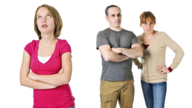 Teenager rolling her eyes, parents in background