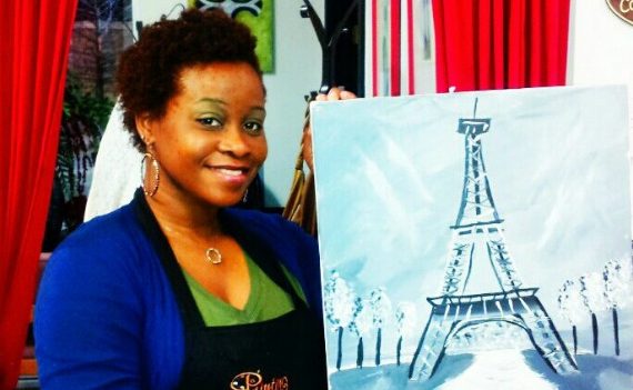 Woman holding up a painting of the Eiffel Tower