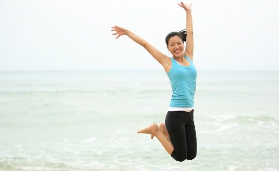 Healthy woman jumping on the beach