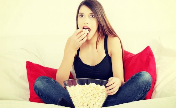 Woman eating popcorn and watching a movie