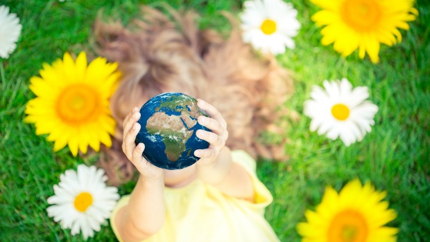 Little girl holding up a globe.