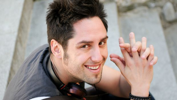 Man sitting with headphones on his shoulders.