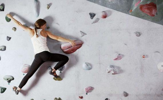 Woman scaling a climbing wall