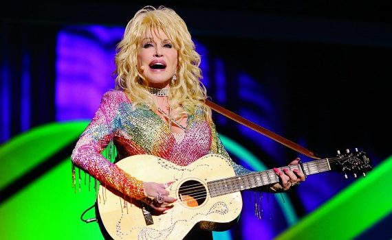 Dolly Parton playing guitar onstage