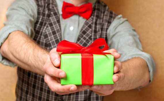 Man holding out a small wrapped present.