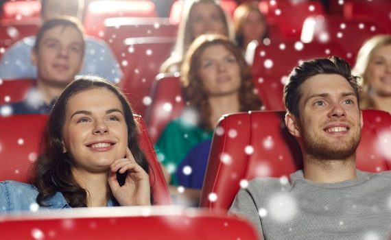 Young couple watching a movie in theater.