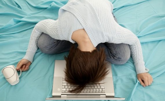 Woman collapsing on her bed.