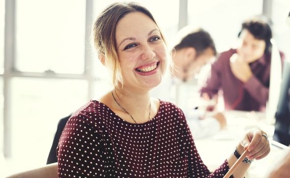 Happy woman in a busy office.