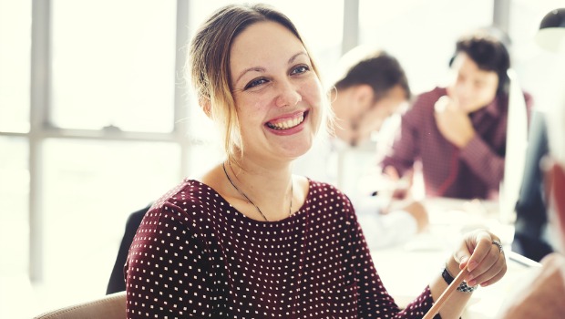 Happy woman in a busy office.