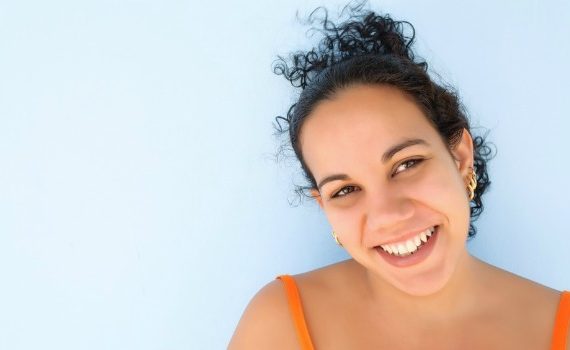 Smiling, attractive dark-haired woman looking straight into the camera.