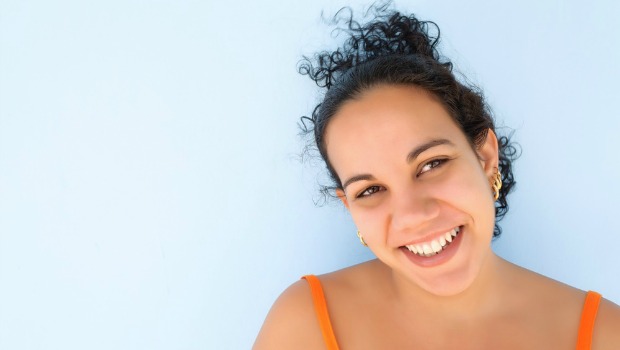 Smiling, attractive dark-haired woman looking straight into the camera.