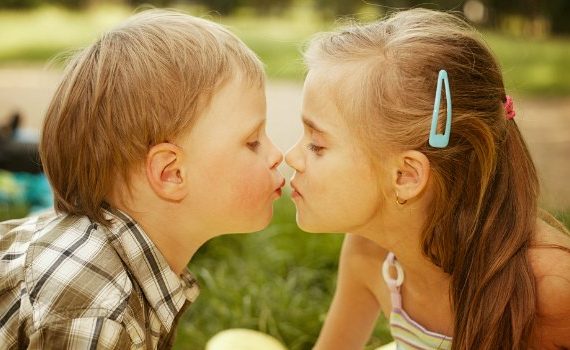 A young boy and girl kissing