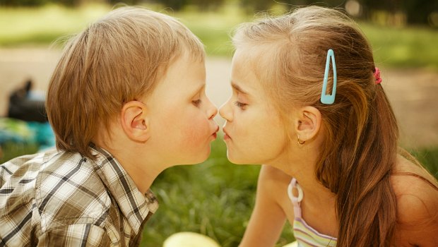 A young boy and girl kissing