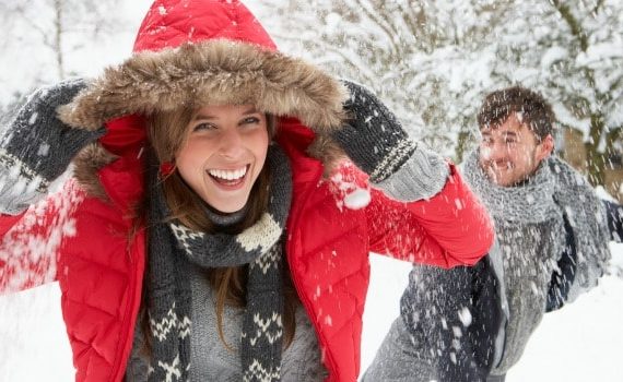 Couple having a fun snowball fight.