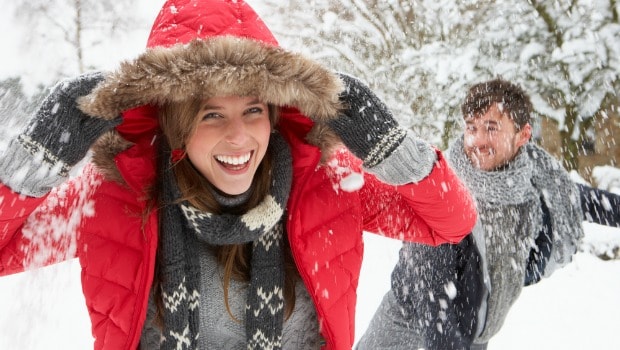 Couple having a fun snowball fight.