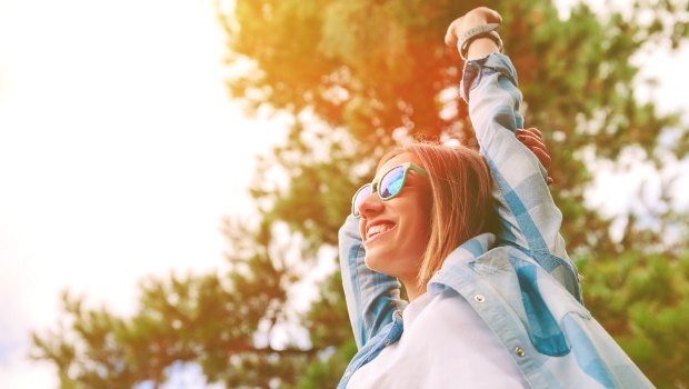 Woman stretching her arms out in nature.