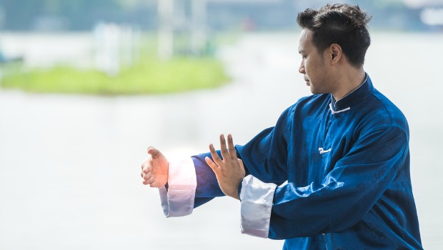 Man practicing qi gong outdoors.