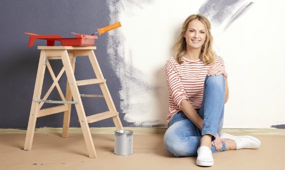 Woman painting walls of her home.