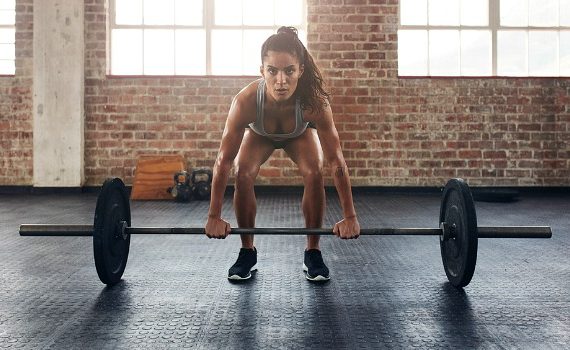 Woman lifting a heavy weight in a gym.