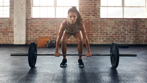 Woman lifting a heavy weight in a gym.