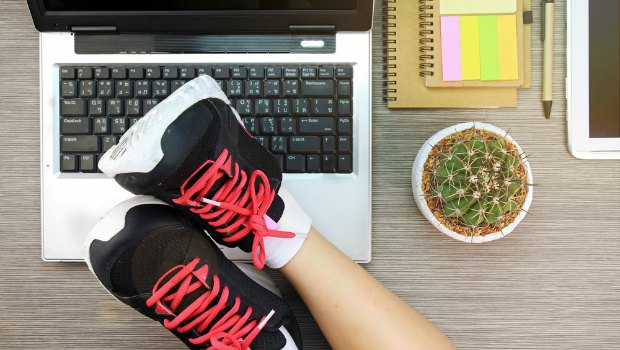 Worker with feet up on her desk.