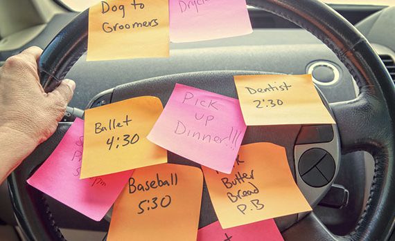 Many post-its on a steering wheel.