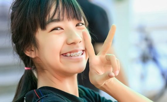 Young Asian woman giving the peace sign.