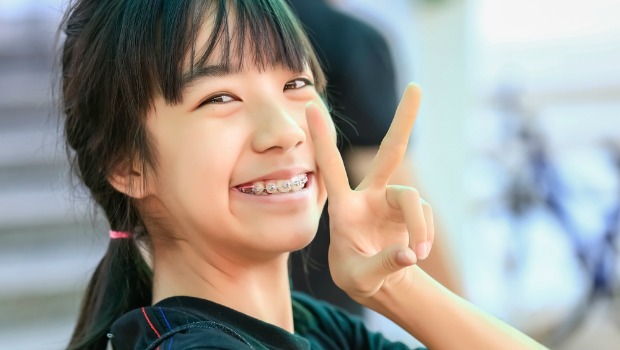 Young Asian woman giving the peace sign.