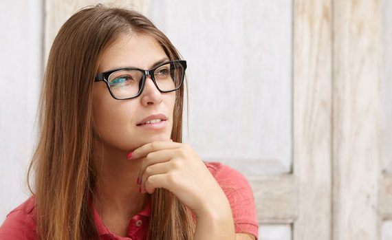 Woman in glasses looking pensive.