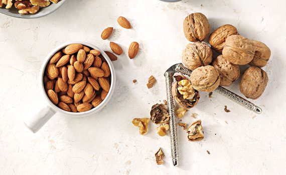 Almonds and whole walnuts being cracked.