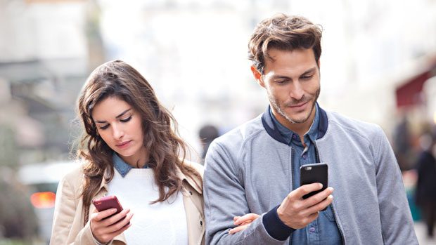 Two people looking at their phones.