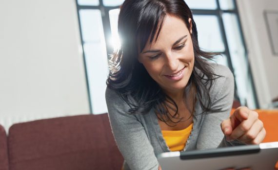 Woman looking at her tablet at home.