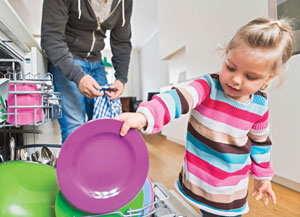 Little girl helping dad with dishes.