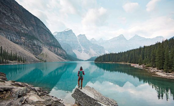 Woman admiring mountains and lake.