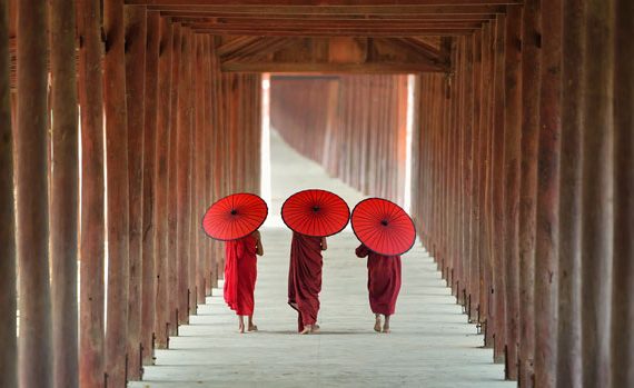 Buddhist monks walking down a corridor.