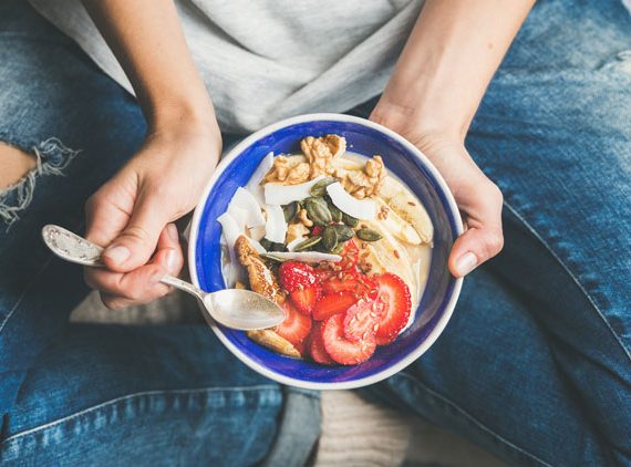 Woman eating bowl of granola.