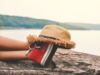 Woman lying down with hat on shoes